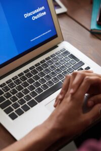 A person viewing a business presentation on a laptop screen, ideal for online learning and work settings.